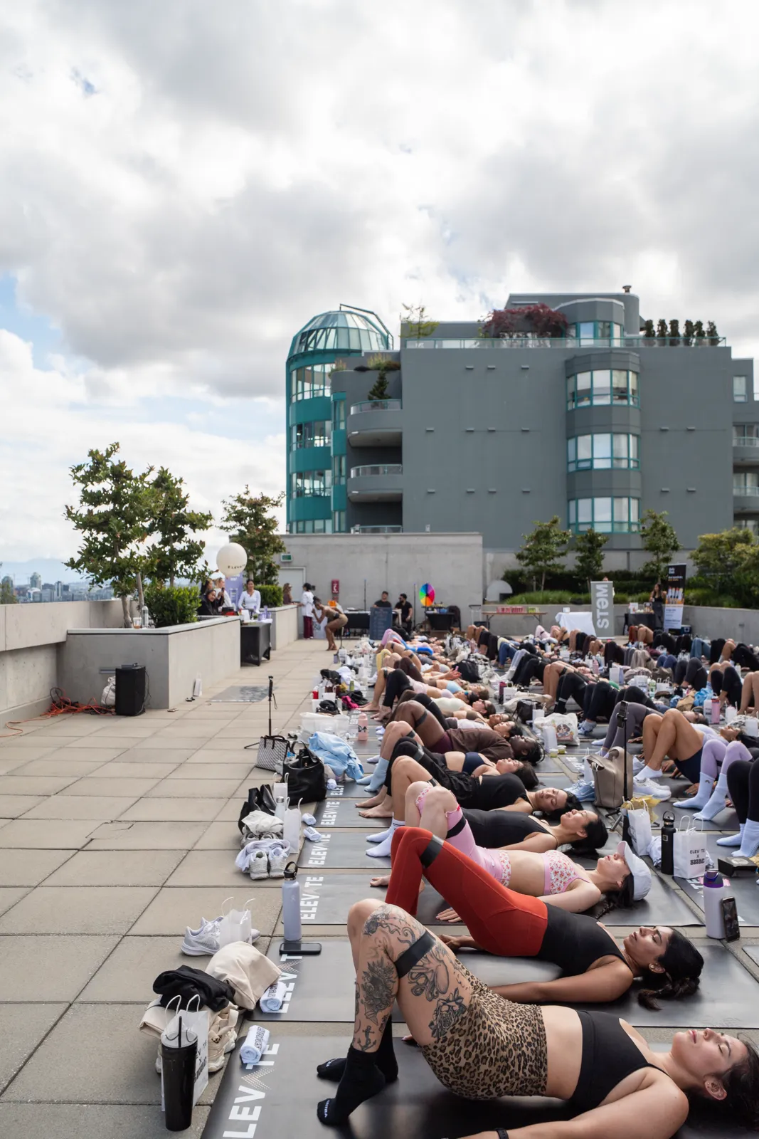 A rooftop mat class in progress, shot down the length of the mats toward the city beyond.