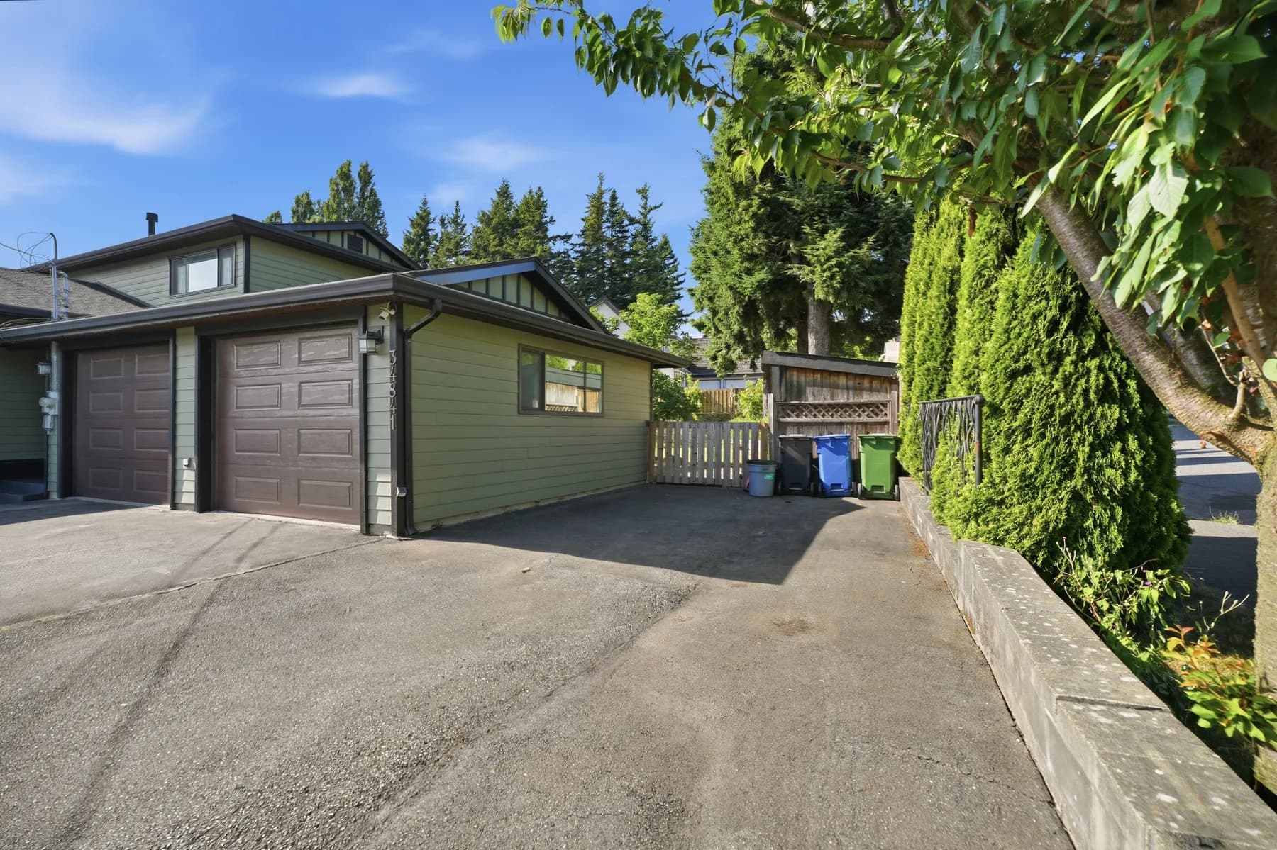 A detached bilevel photographed largely vacant: a renovated grey kitchen open to dining, the main living space, the rear garden and a detached double garage.