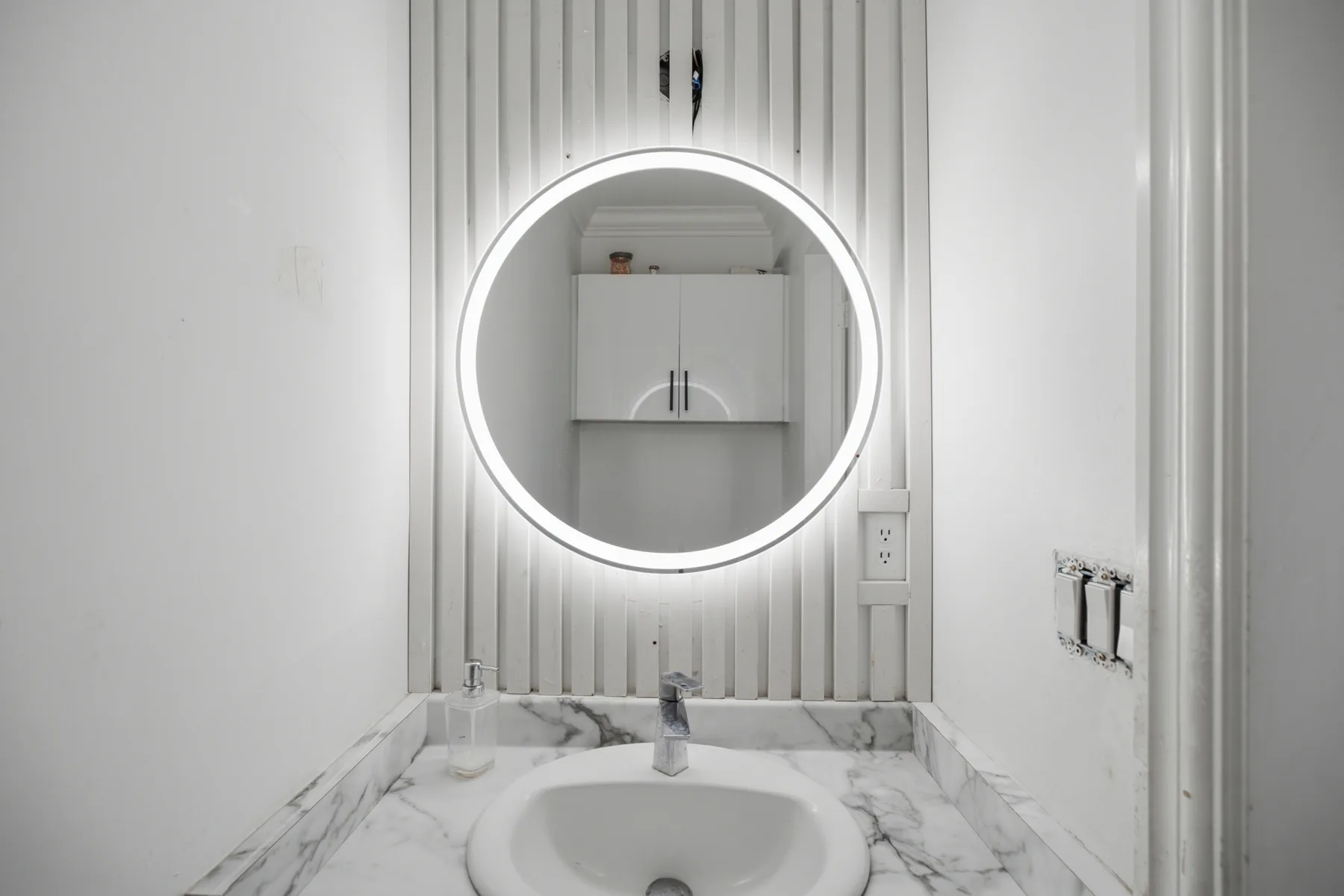 A fully renovated townhouse: a marble-look kitchen, the unit frontage under its carport, the main living space, and a full-height tiled bathroom.