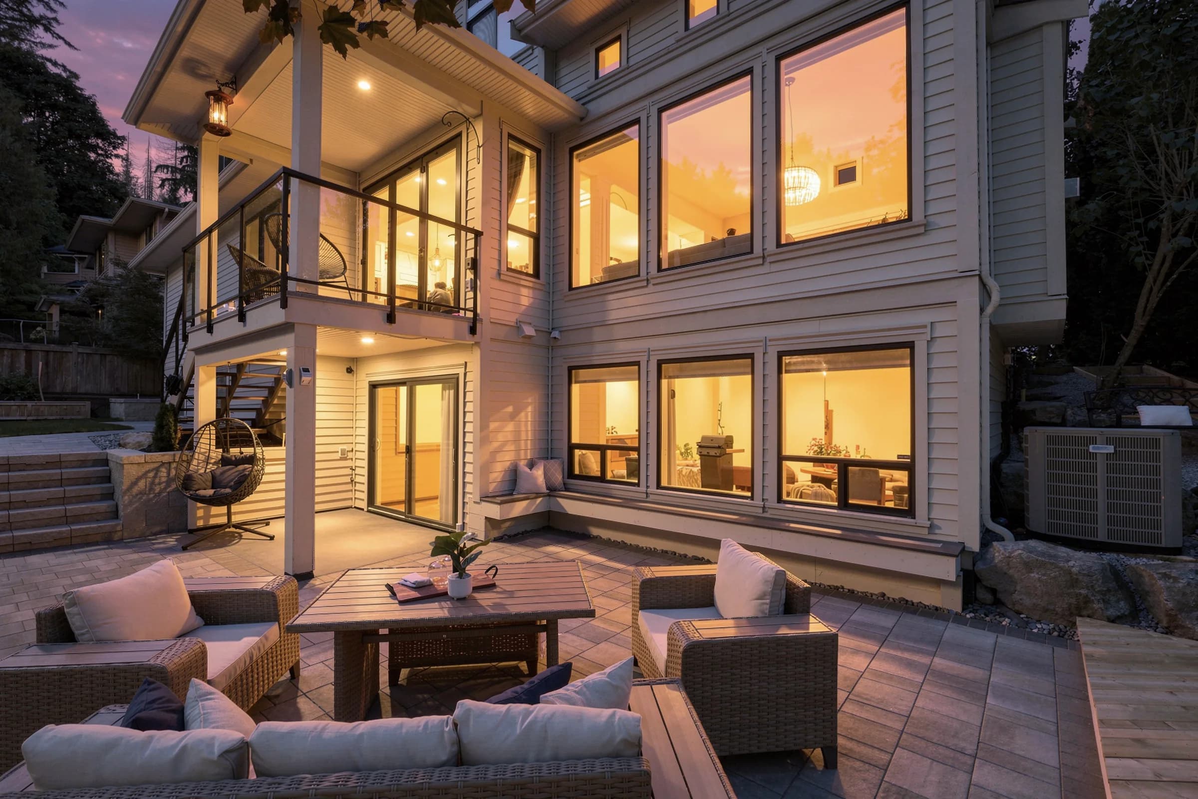Twilight rear elevation with every window lit — the frame a listing film ends on.